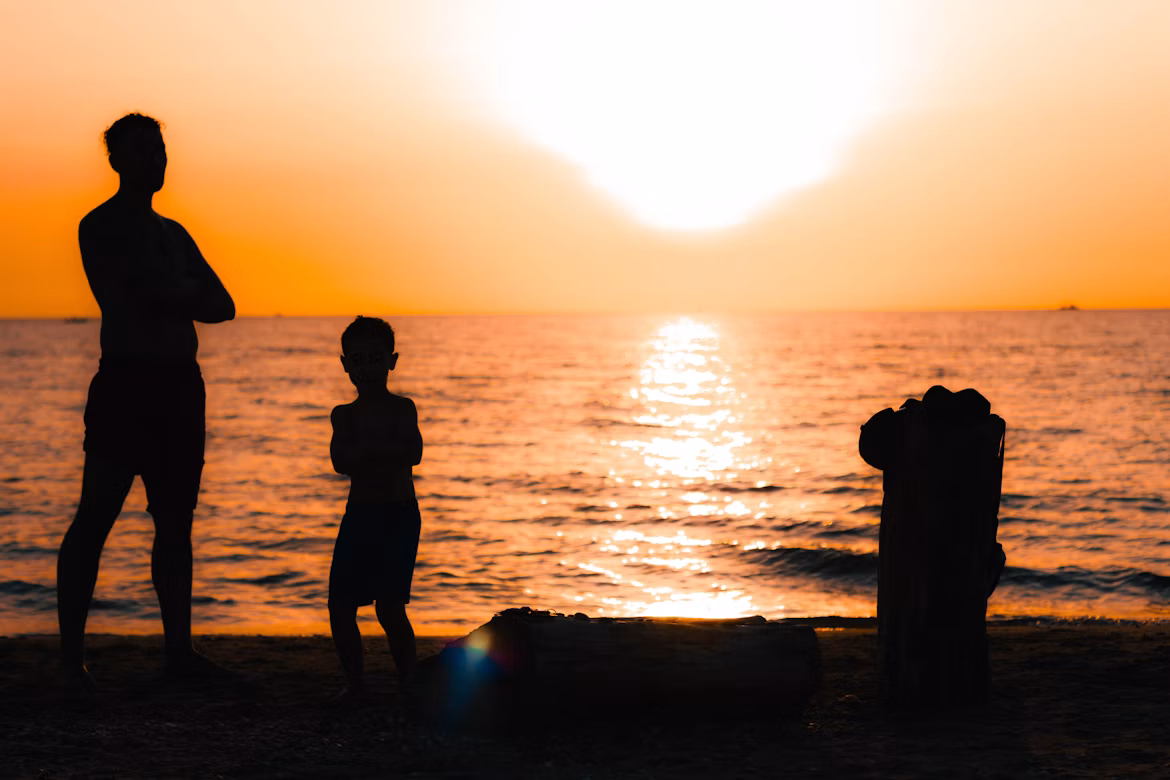 Un padre y su hijo mirando el atardecer
